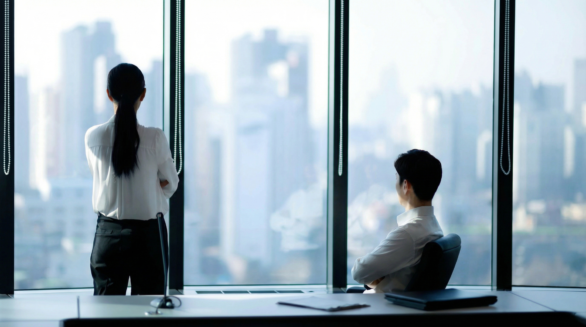 Business professionals in modern office overlooking city skyline - NeoSapiens Executive Search